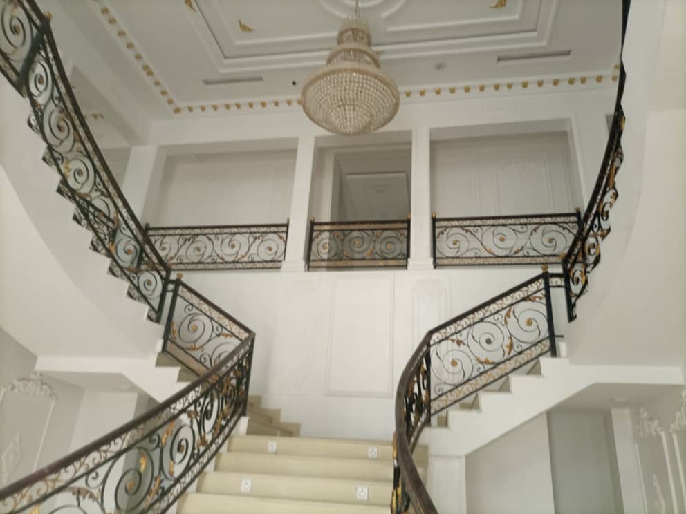 House interior with a double staircase and chandelier